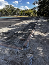 a tennis court is being built in the middle of a wooded area