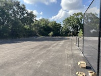 a tennis court in the middle of a parking lot